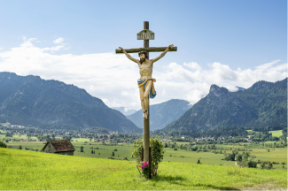 Ein Wegkreuz vor Bergkulisse