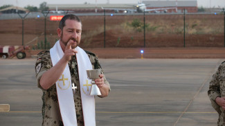 Ein Militärpfarrer segnet einen Abendmahlskelch